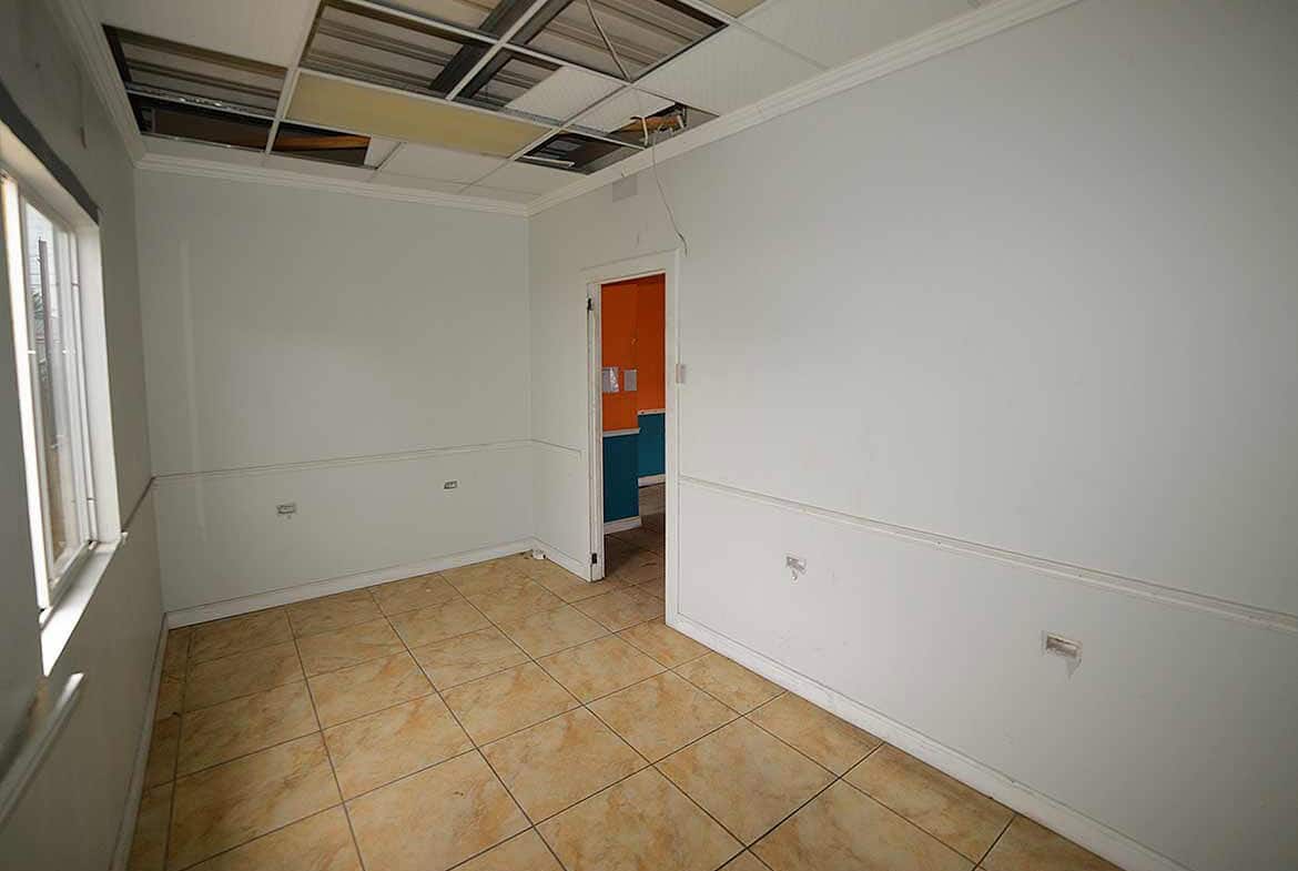 Cornerstone- Empty room with damaged ceiling and tiled floor, under renovation.