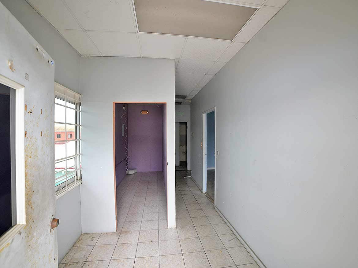 Interior of a Commercial Building Cornerstone- Empty corridor inside a commercial building with windows and doorways.