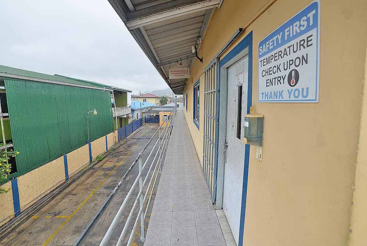 Cornerstone- Building entrance with safety sign and temperature check notice.