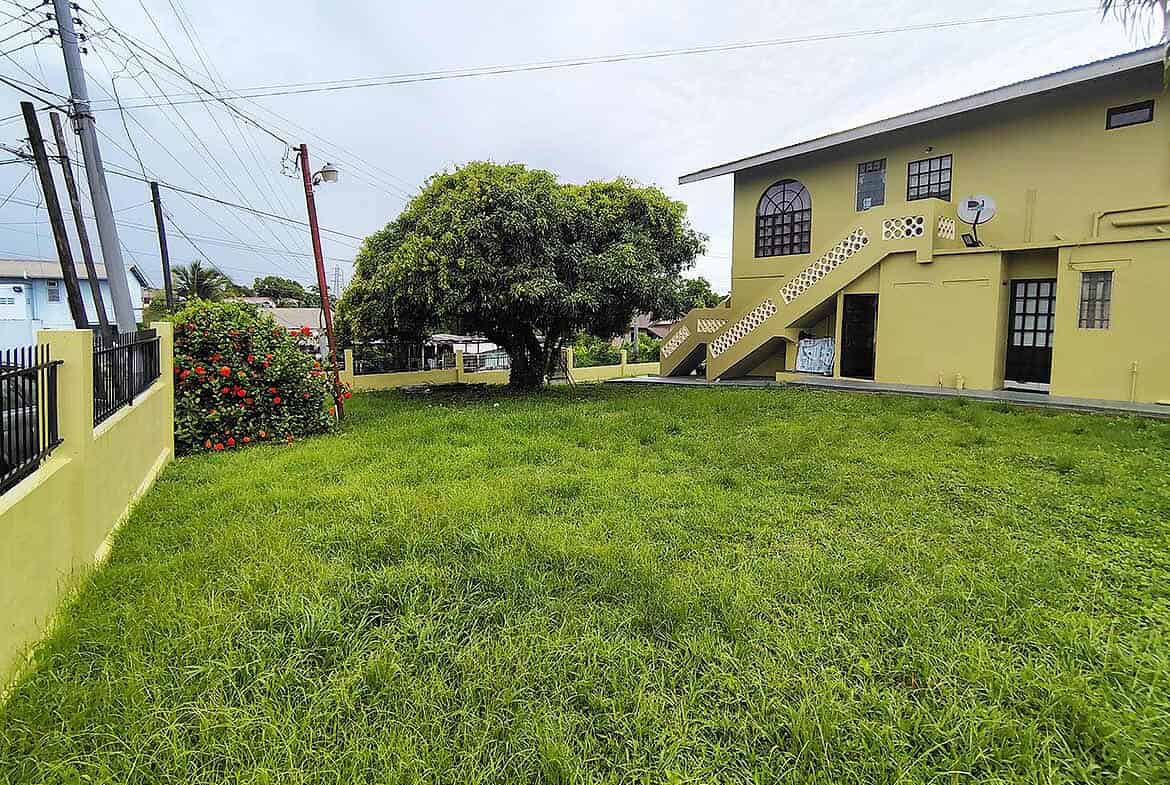 Cornerstone- Yellow house with stairs and lush green yard in Corinth.
