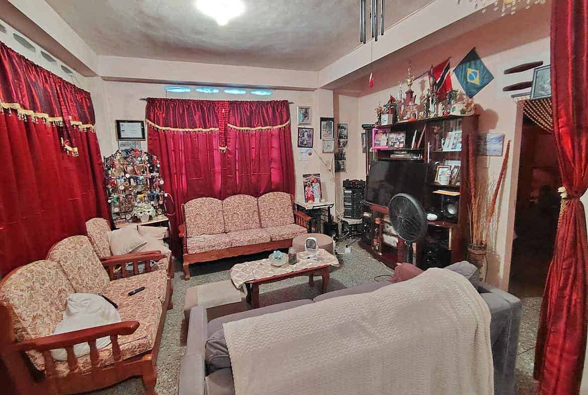 Cornerstone- Living room with red curtains, vintage furniture, and entertainment center.