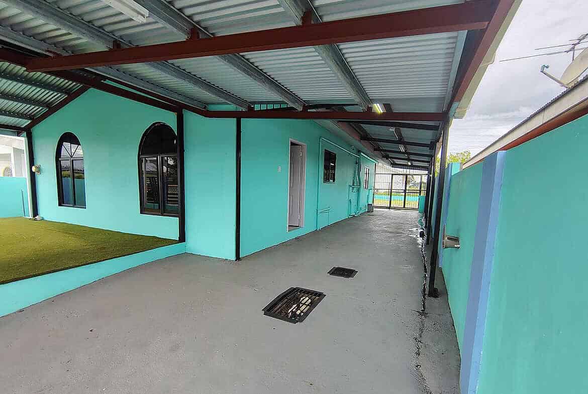 Cornerstone- Colorful building exterior at Cashew Gardens with covered walkway.