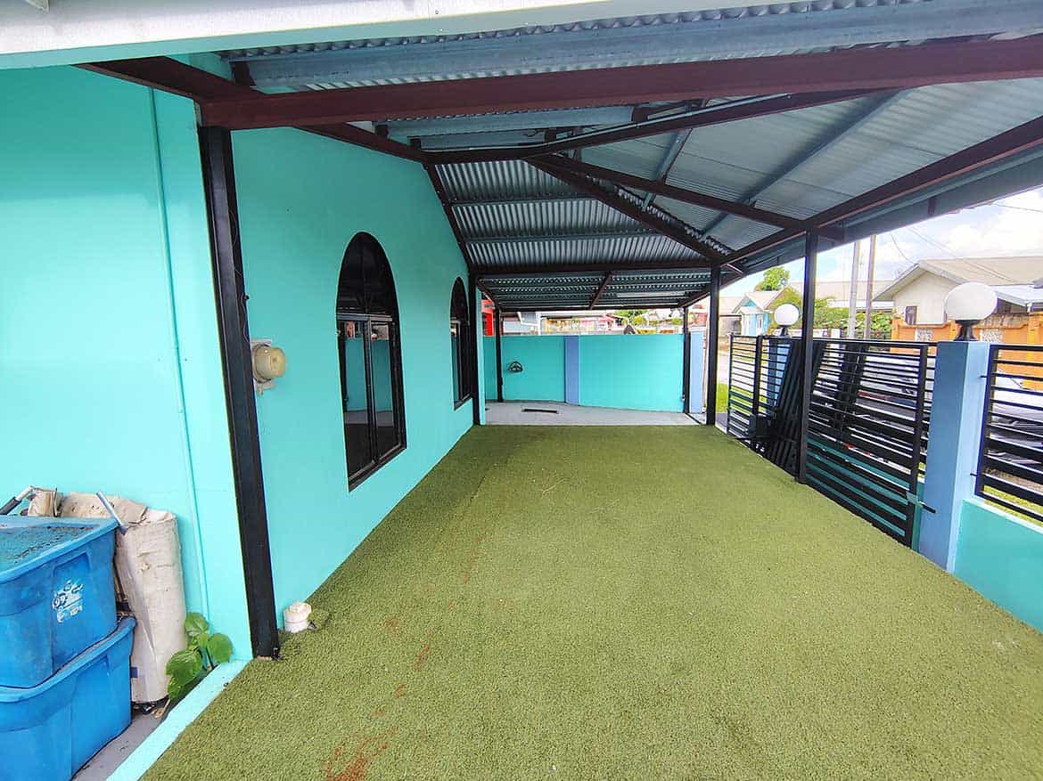 Colorful Terrace at Cornerstone™ Cornerstone- Bright turquoise building with black window frames and green artificial grass.