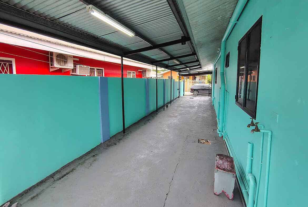 Cornerstone- Vibrant turquoise building with a covered walkway in Edinburgh.