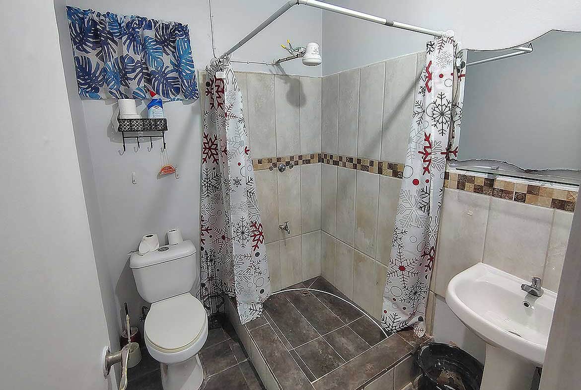 Cornerstone- Bathroom with shower, toilet, and sink at Cashew Gardens, Edinburgh.