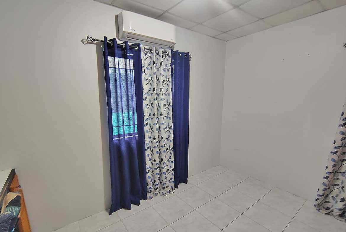 Cornerstone- Room with air conditioning and blue curtains at Cornerstone™.
