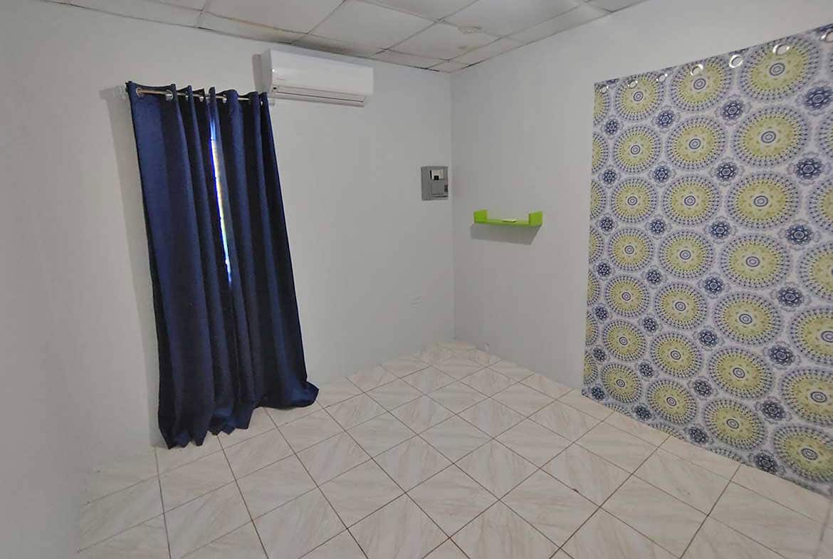 Cornerstone- Interior room at Cashew Gardens with curtains and patterned wall.
