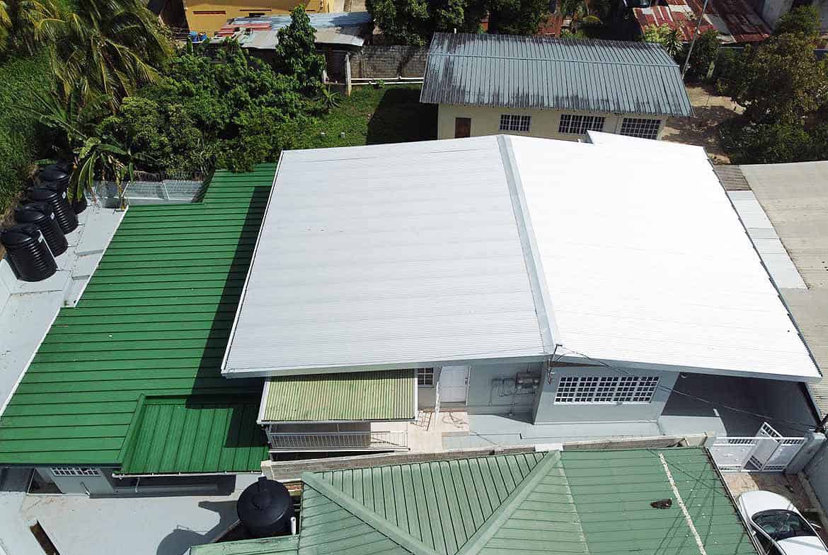 Cornerstone- Aerial view of apartment building roofs with green and white metal roofing.