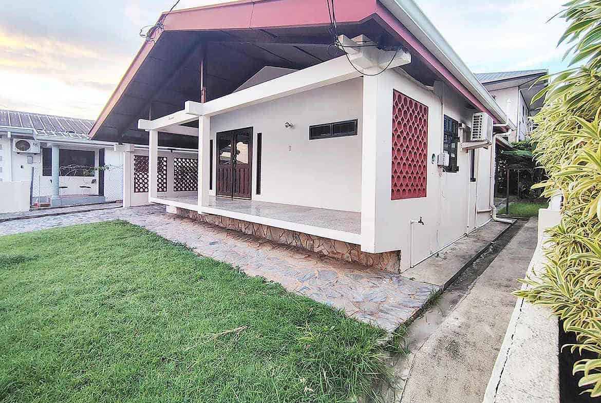 Cornerstone- Modern 3-bedroom home with a spacious porch and lush lawn.