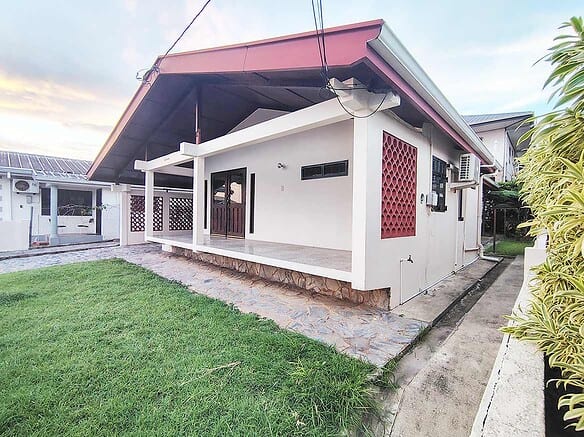 Cornerstone- Modern 3-bedroom home with a spacious porch and lush lawn.