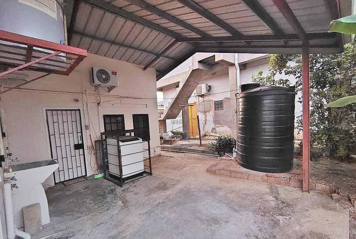 Cornerstone- Large black water storage tank in backyard of 3-bedroom home in Dinsley Gdns.
