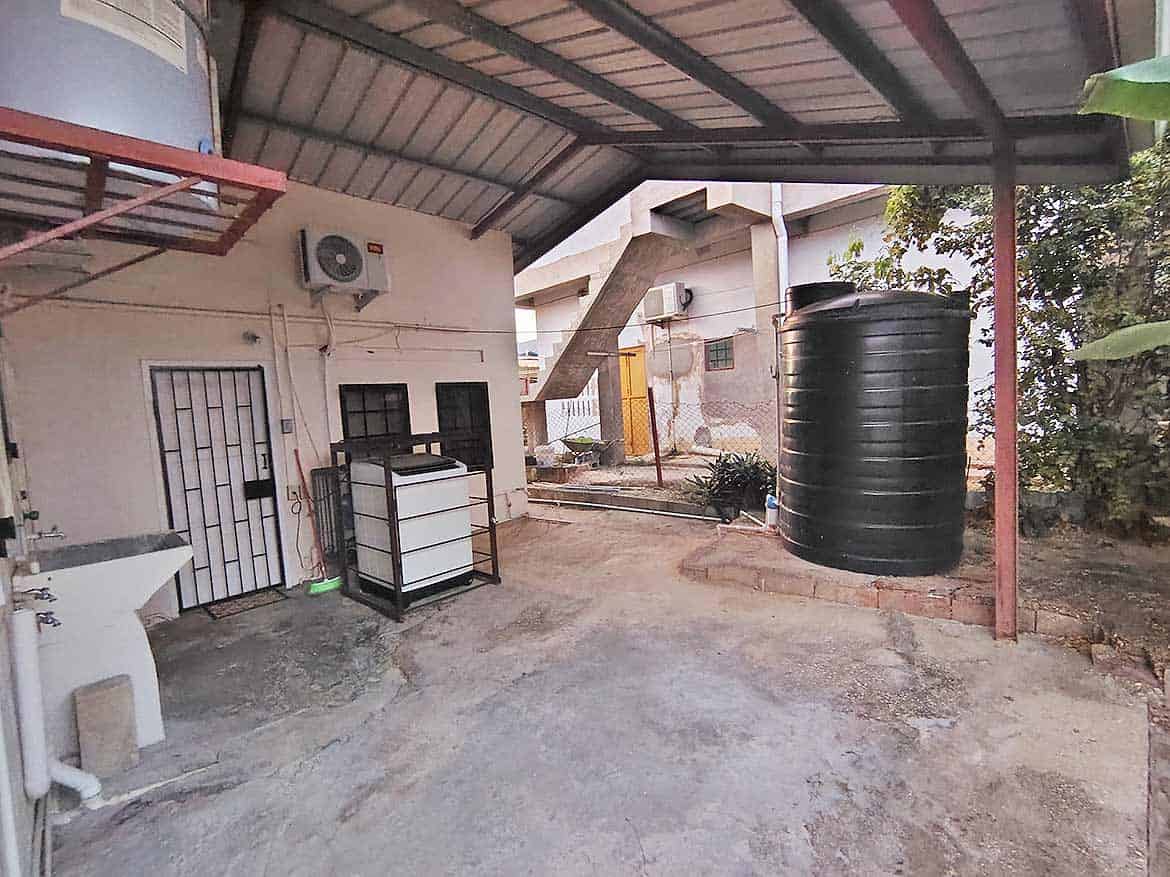 Outdoor Water Storage Tank at Dinsley Gdns Cornerstone- Large black water storage tank in backyard of 3-bedroom home in Dinsley Gdns.