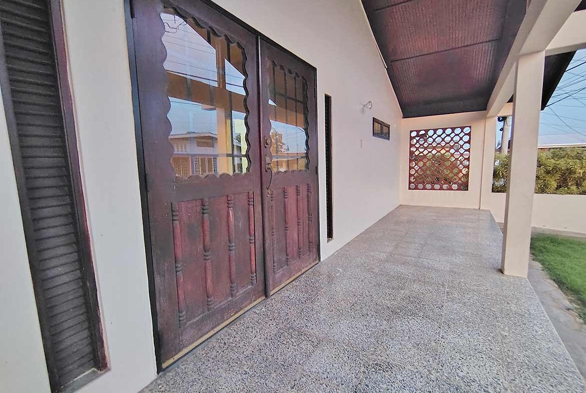 Cornerstone- Front porch of a 3-bedroom home with wooden doors and tiled flooring.
