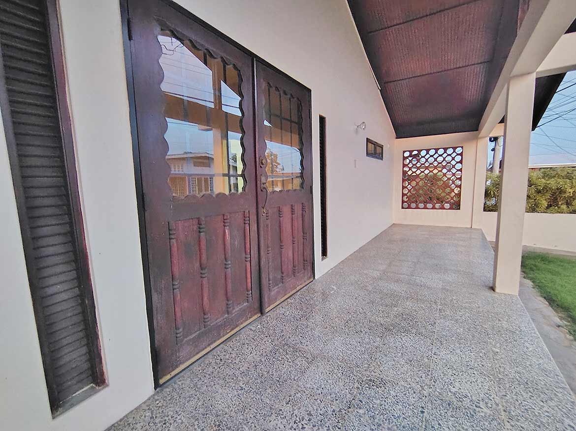 Cornerstone™ 3-Bedroom Home Exterior Cornerstone- Front porch of a 3-bedroom home with wooden doors and tiled flooring.