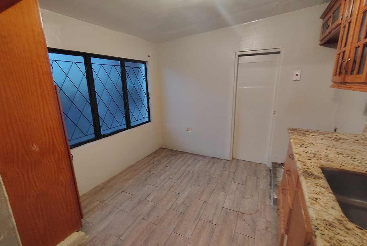 Cornerstone- Spacious kitchen with window view in Dinsley Gardens home.