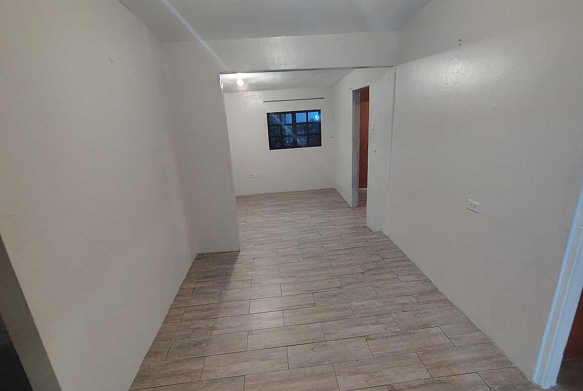Cornerstone- Spacious living area with wooden flooring and window in Dinsley Gdns home.