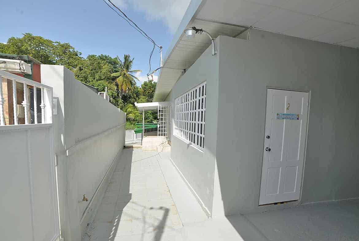 Cornerstone- Modern apartment building exterior with white walls and glass block windows.