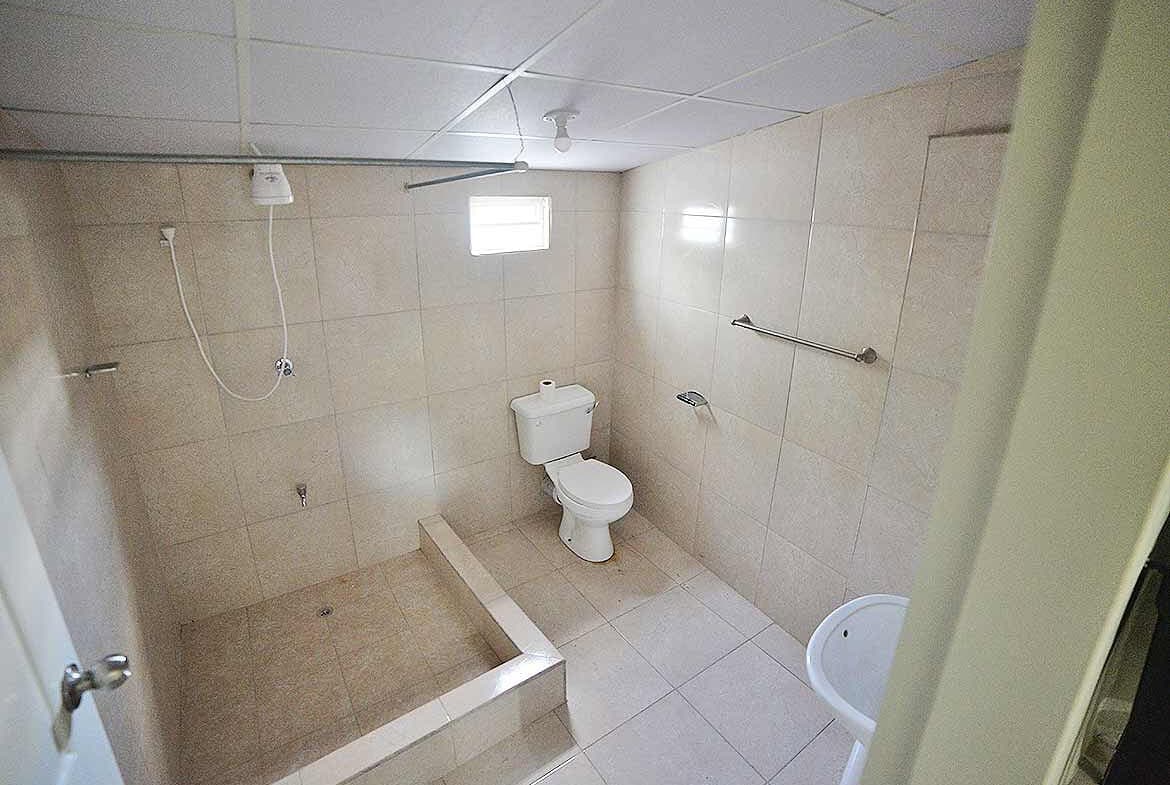 Cornerstone- Accessible bathroom with shower, toilet, and grab bars in Five Rivers apartment.