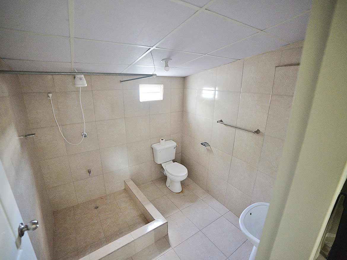 Bathroom in Apartment Building Five Rivers Cornerstone- Accessible bathroom with shower, toilet, and grab bars in Five Rivers apartment.