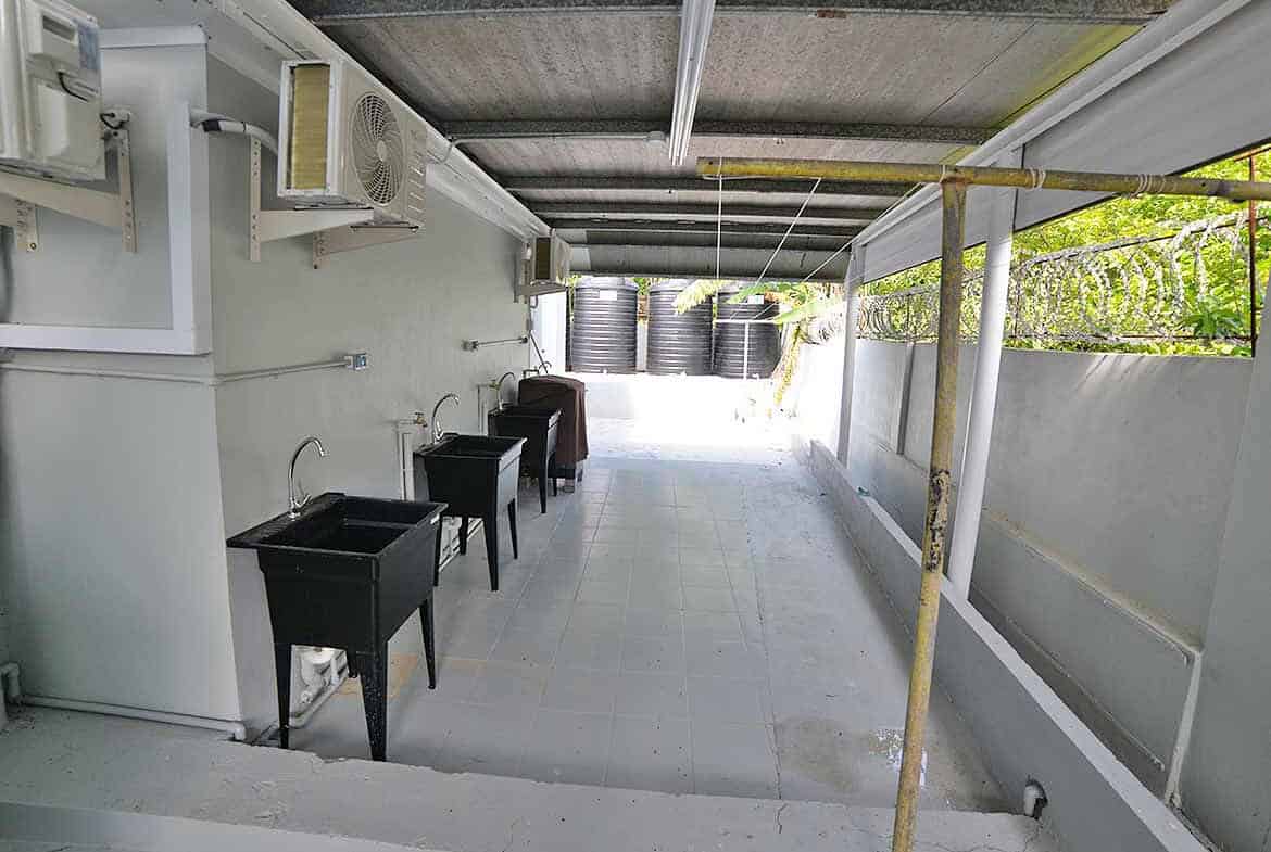 Cornerstone- Balcony area with water tanks and seating at Five Rivers apartment building.