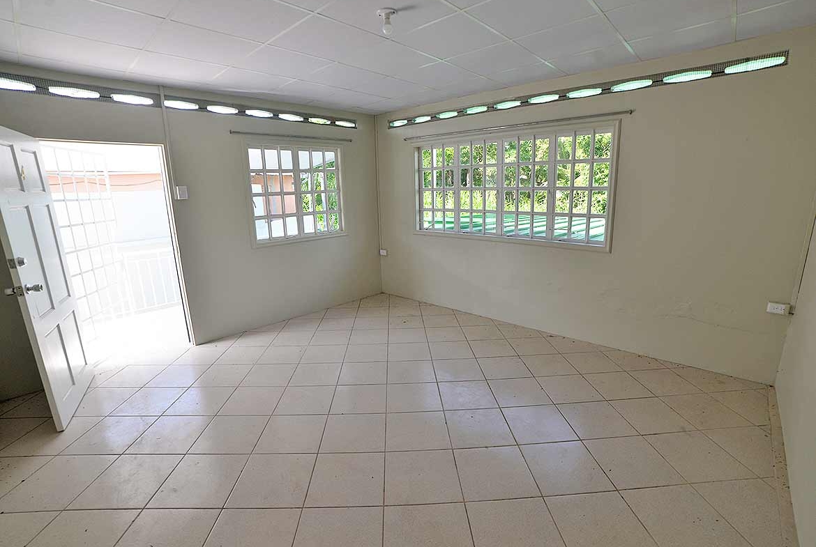 Cornerstone- Empty room with large windows in Five Rivers apartment building.