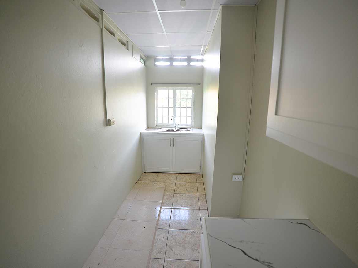 Interior of Apartment Building Five Rivers Cornerstone- Bright kitchen with window and white cabinets in Five Rivers apartment.