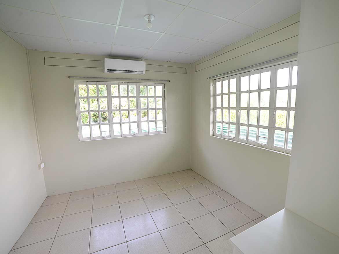 Interior of Apartment at Five Rivers Cornerstone- Bright empty room with large windows and air conditioning unit.